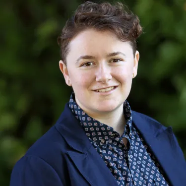 Serena Geroe headshot with a blue patterned shirt and navy blazer