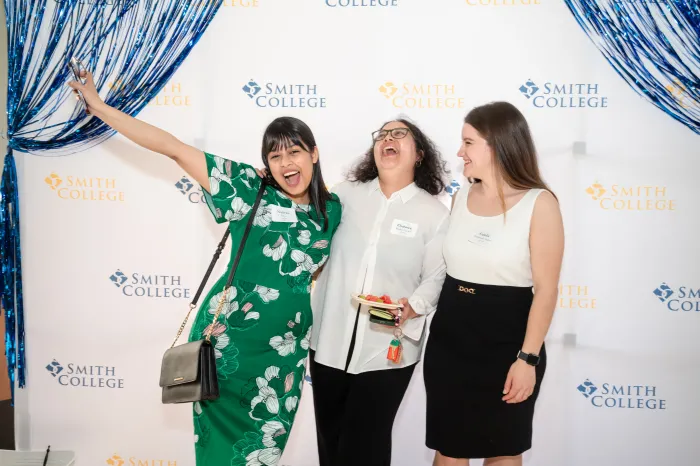 Three students laughing together at the senior soiree.