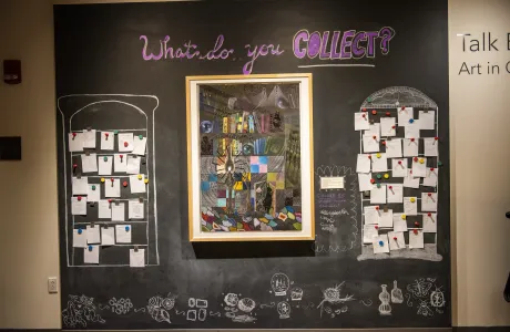 An interactive chalkboard activity in the Smith art museum, asking visitors to answer the prompt, "What do you collect?"