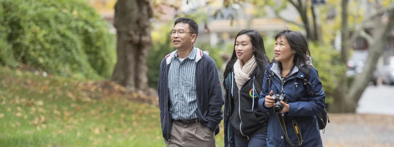 A student and their family walking on campus.