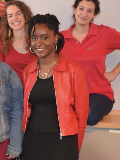 Ifetayo Harvey with co-workers, all of whom are dressed in red and smiling