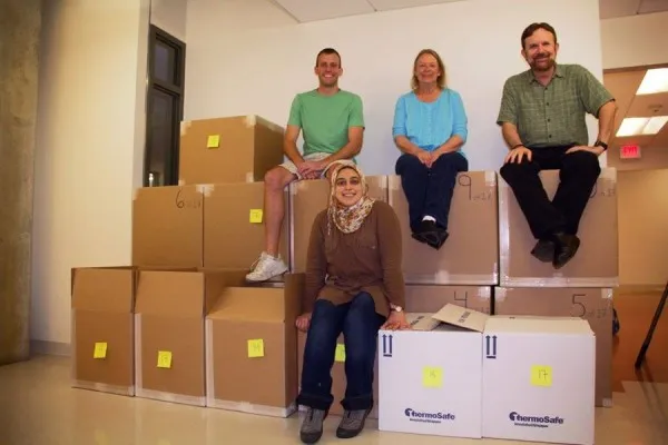 Four people sitting on boxes