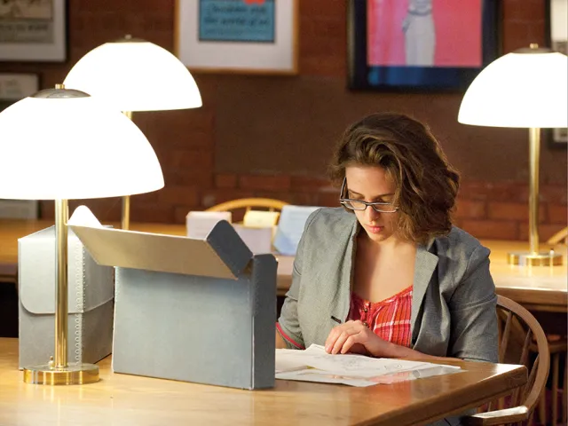 Student working with papers at a table in the college archives