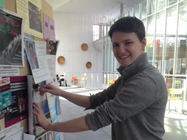 Julia Edwards '15, founder of Smithes in Computer Science, puts up posters for the college's first hackathon March 28-29.