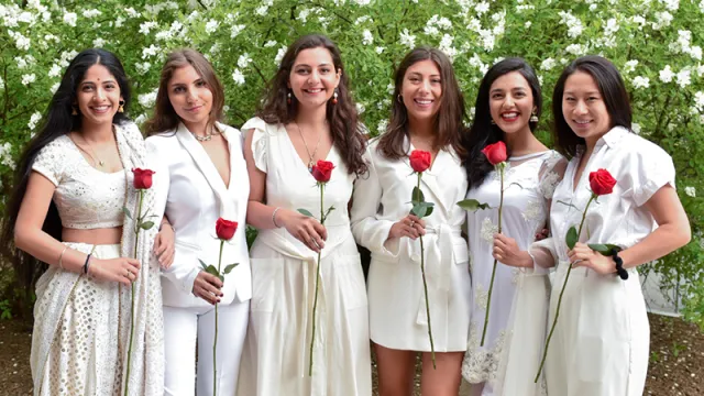 Six students holding red roses on Ivy Day