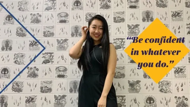 Joyce Kim in front of black and white tile with words "Be confident in whatever you do"