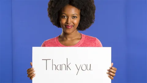 Belise Bwiza holding a sign saying Thank you