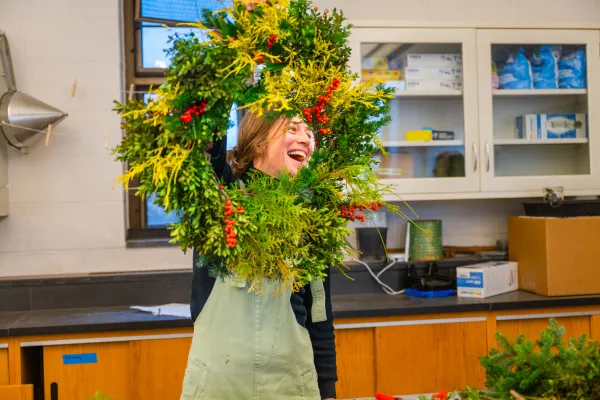 Julie Thomson laughs while holding a completed wreath