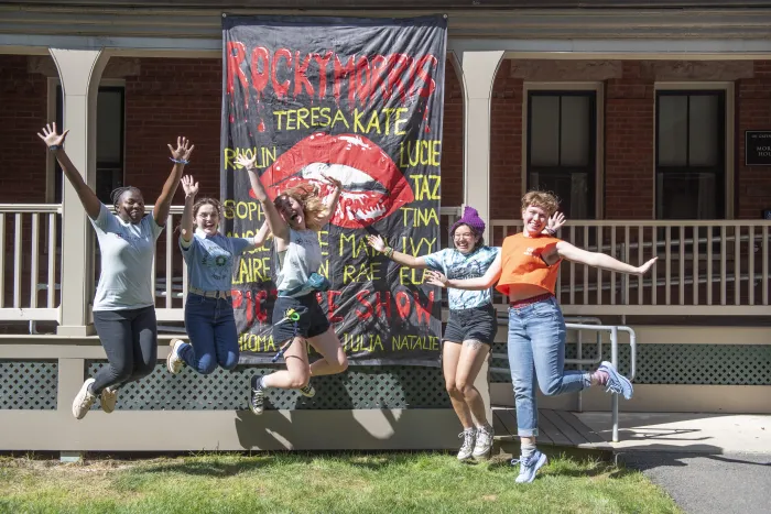 Residents of Morris House jump in front of their house banner for the year, which reads "Rocky Morris Picture Show"