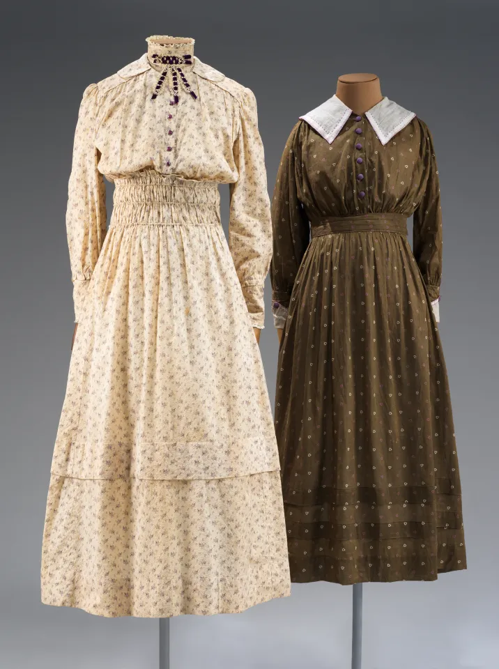 Cream and brown-colored long-sleeved dresses, cinched at the waists.
