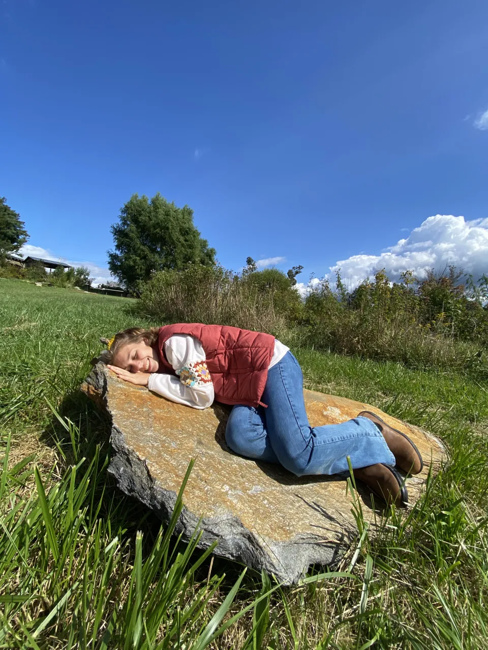 Kaylee Newbanks ‘24 laying on a rock outside