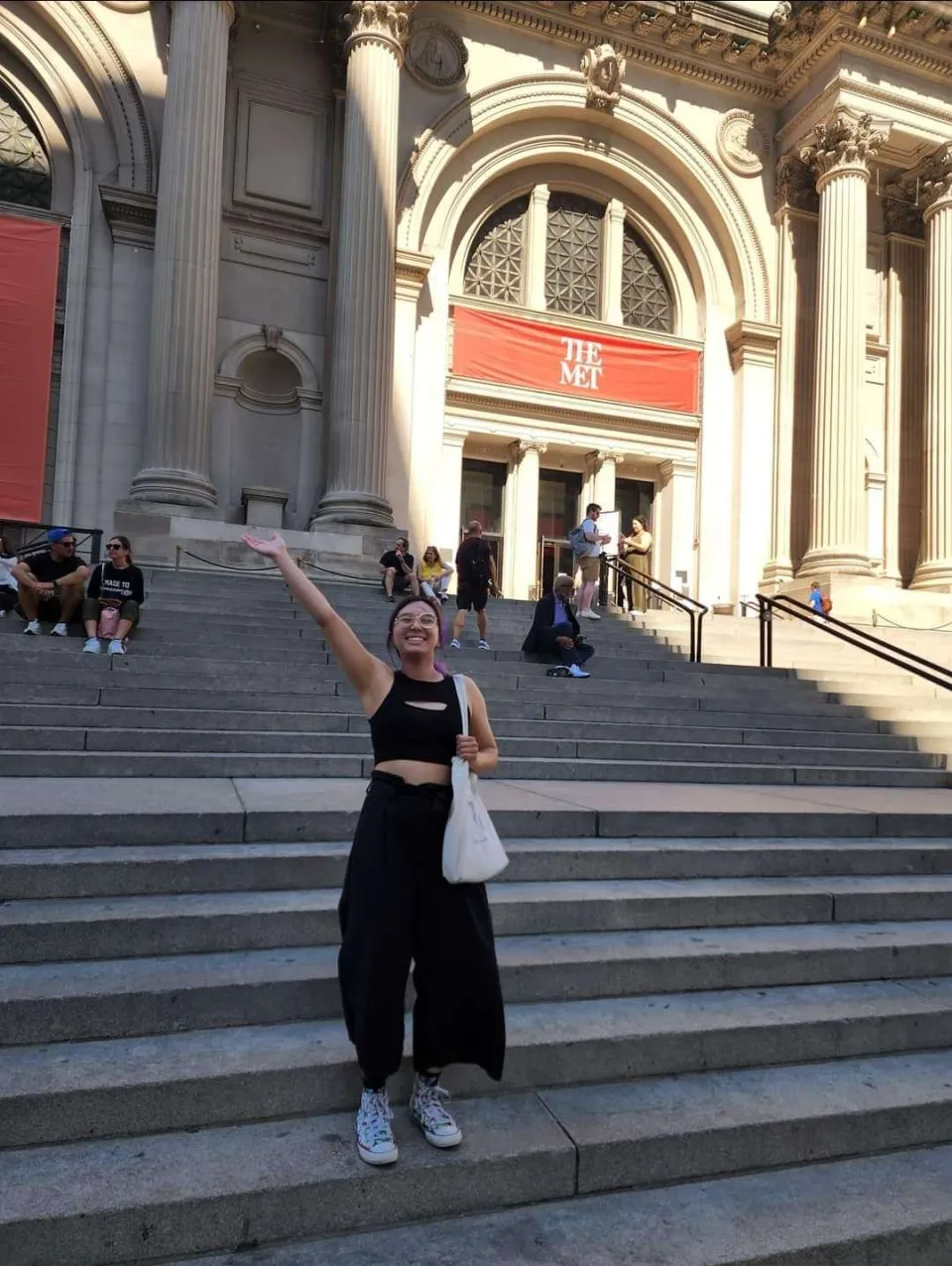 Cloud Osmond '24 standing in front of a building and waving