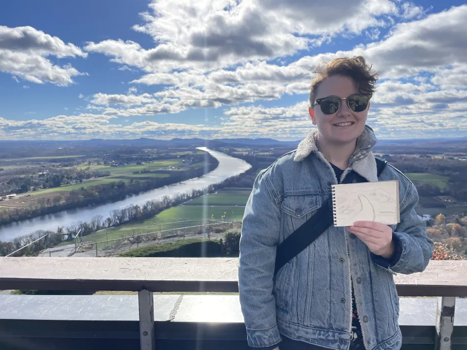 Serena Geroe holding a drawing on Mount Sugarloaf